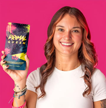 Person holding a colorful 'Primal Queen' product against a pink background.